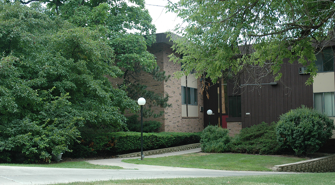 A building with a green lawn in front.