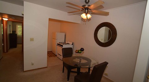 A dining room with a glass table and chairs.