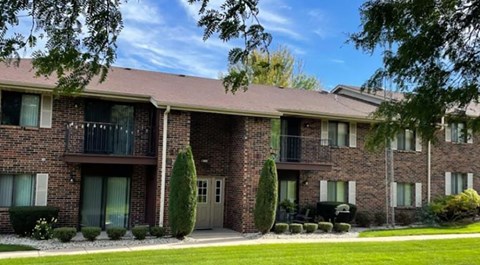A brick apartment building with a balcony on the second floor.
