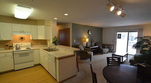 A kitchen with white appliances and wooden floors.