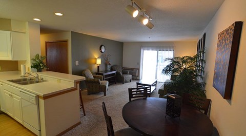 A living room with a kitchen area in the background.