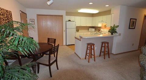 A kitchen with a table and chairs in the middle of the room.