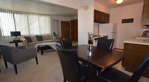 A dining room with a table and chairs.