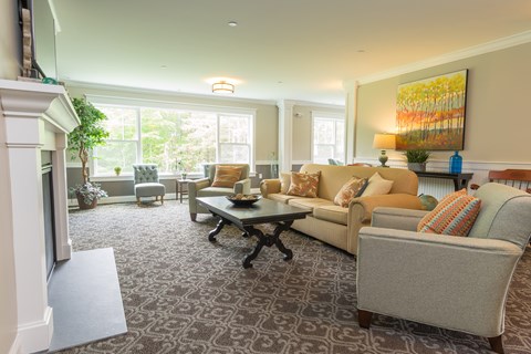 A living room with a fireplace and a painting on the wall.