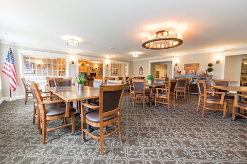 A dining room with a large table and chairs.
