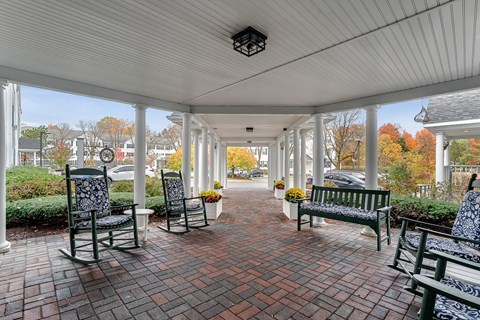A covered walkway with benches and chairs.