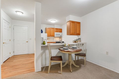 A kitchen with a table and chairs in the middle of the room.