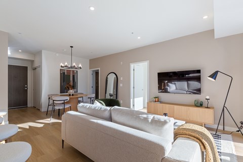 A modern living room with a white sofa and a television.