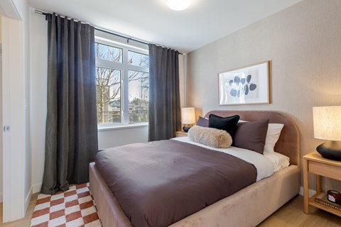 A bedroom with a large bed and a window with curtains in Hillcrest Ave located in Abbotsford, BC