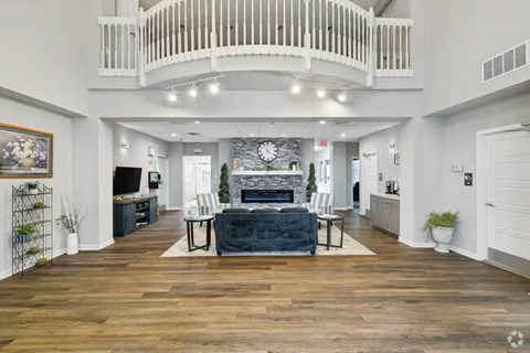 A spacious living room with a fireplace and a balcony.