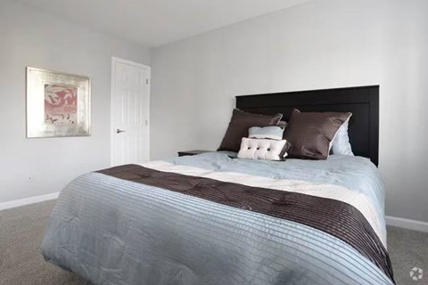 A bed with a striped comforter and two pillows is in the image.
