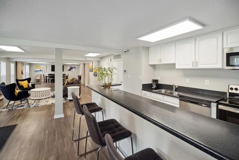 Modern kitchen with long counter and bar stools at Villages at Gateway, Denver, Colorado