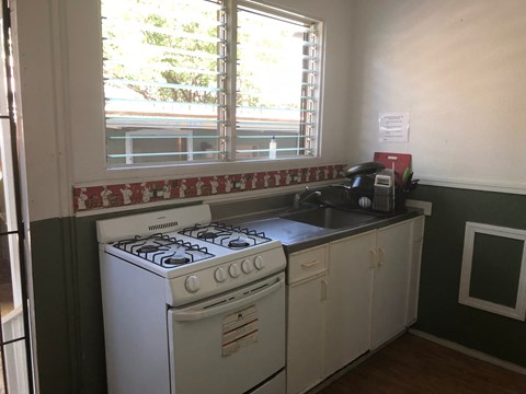 A white gas stove in a kitchen with green walls.