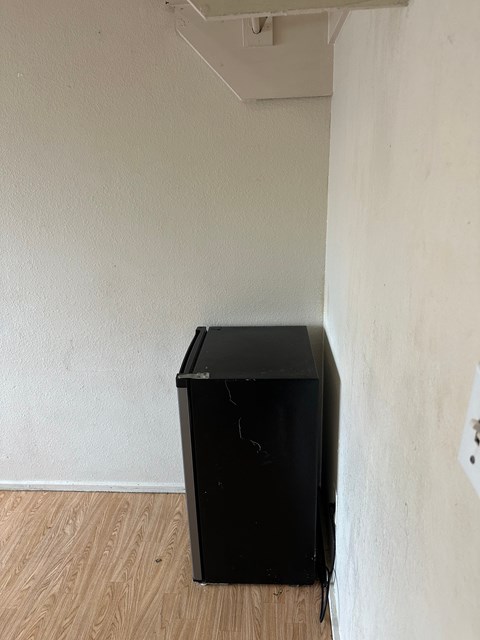 A black box is on a wooden floor in a room.