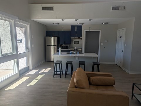 A kitchen with a refrigerator, microwave, and oven is visible.