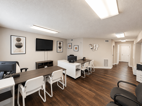 A conference room with a long table and chairs located at the pointe apartments in Pasadena, Tx