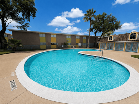 A round swimming pool in front of a building.