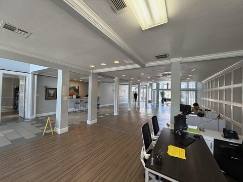 A spacious office with wood floors and white walls.