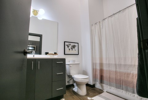A bathroom with a toilet, sink, and a shower curtain.