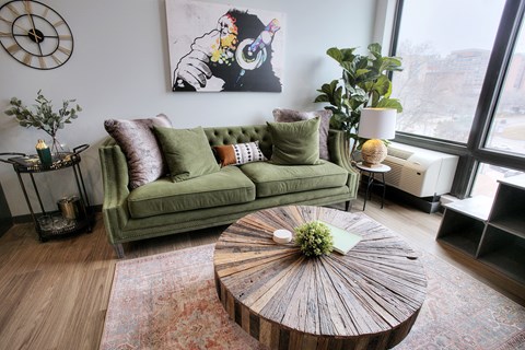 A living room with a green couch and a wooden coffee table.