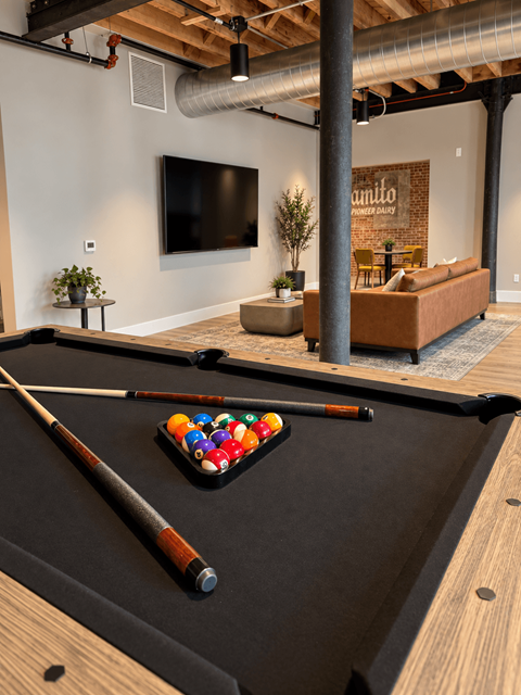 A pool table with a cue and balls in the middle of it.