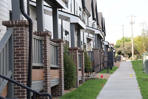 Row of modern townhomes with brick columns at Little Bo Bungalow and Flats Apartments, Omaha, NE