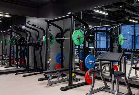 A gym with a variety of weightlifting equipment.