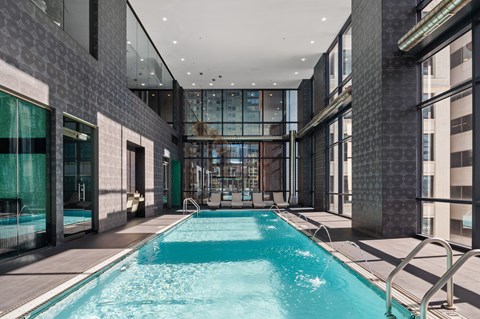 A long rectangular pool with a metal railing on the side.