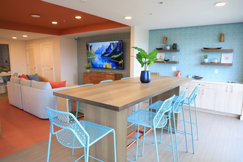 A modern dining room with a wooden table and blue chairs.