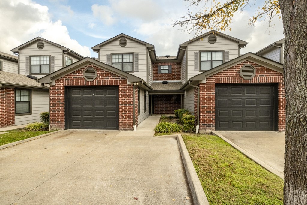the front of a house with two black garage doors