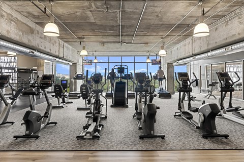 A spacious gym featuring various exercise equipment at Allure Herman Park in Houston, TX