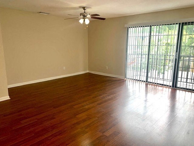 a living room with a ceiling fan and a sliding glass door