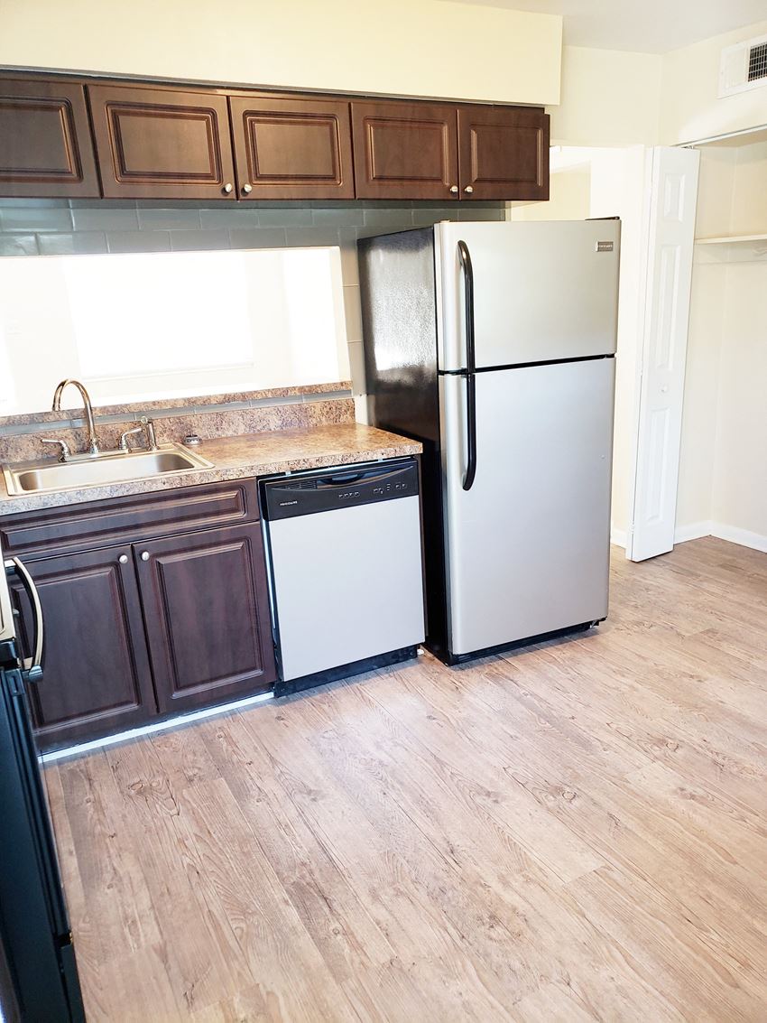 an empty kitchen with a dishwasher sink and refrigerator - Photo Gallery
