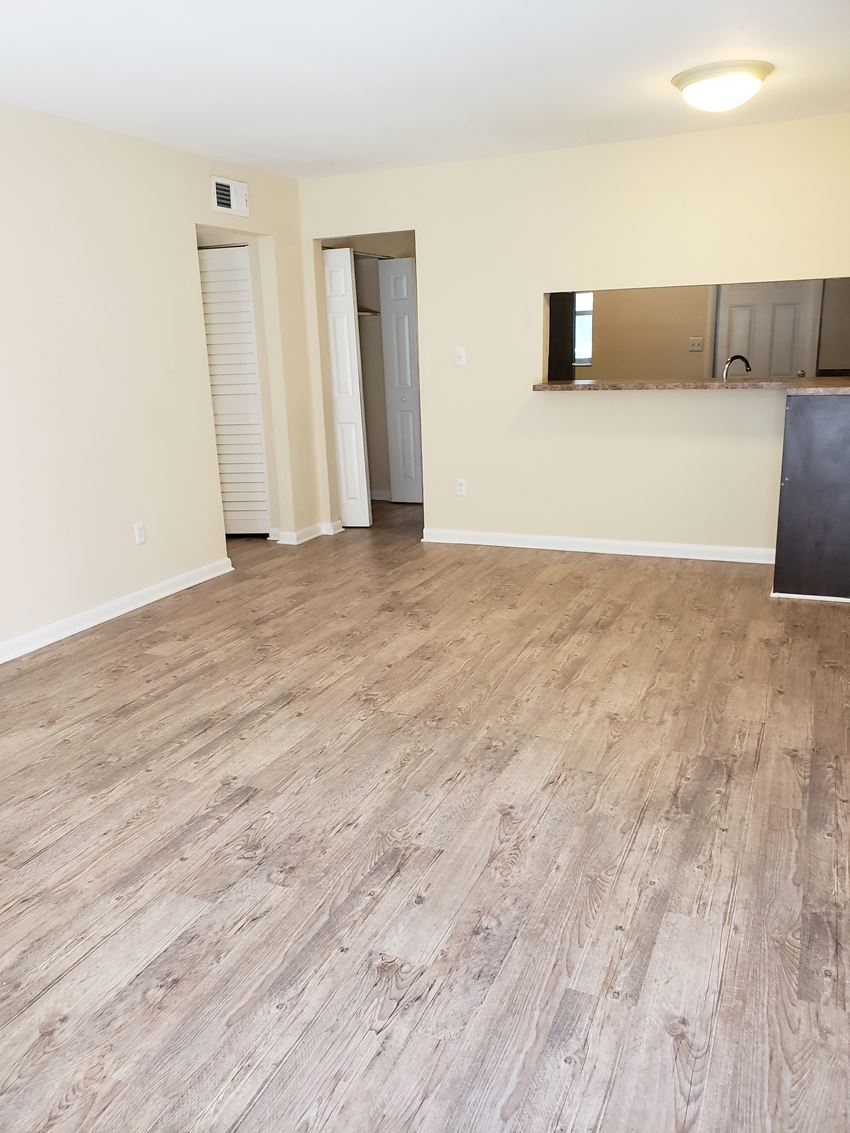 an empty living room with a hardwood floor - Photo Gallery