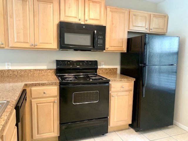 a kitchen with a black stove top oven and a black refrigerator