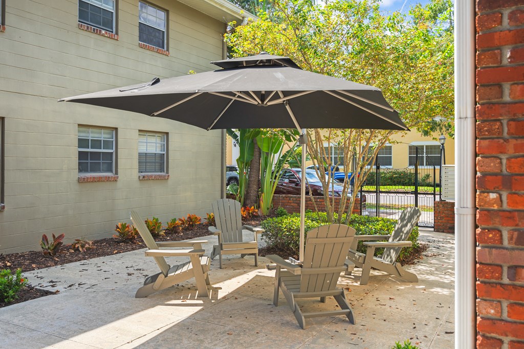 a patio with a table and chairs in front of a building