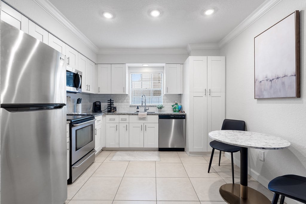 a kitchen with white cabinets and stainless steel appliances