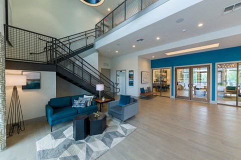 a living room with a staircase and blue couches