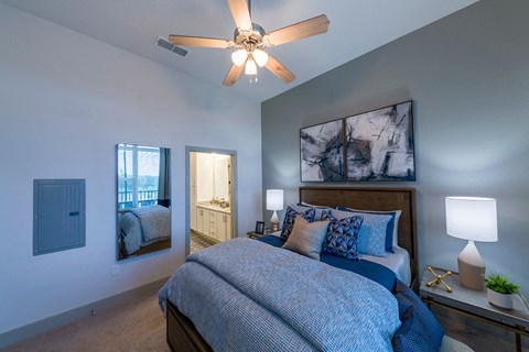Bedroom with blue linens and artwork at Ciel Luxury Apartments, Jacksonville, FL