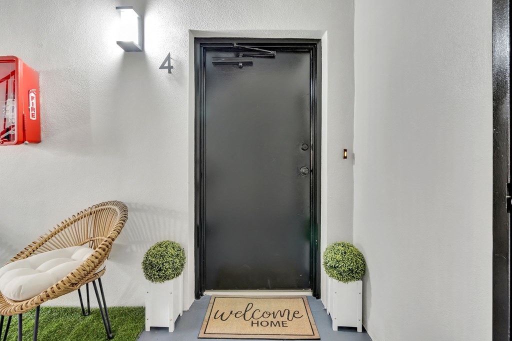 a front door with a welcome home sign in front of it