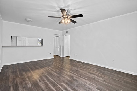 a living room with white walls and a ceiling fan