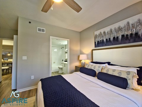 A bedroom with a large bed and a ceiling fan.