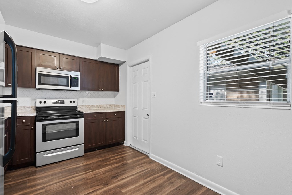 a kitchen with wood floors and white walls