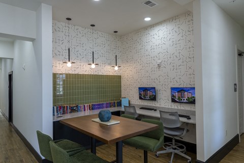 A conference room with a table, chairs, and a wall covered in pictures.