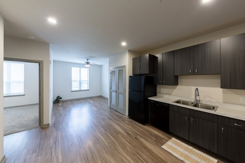 A kitchen with black cabinets and a white countertop.