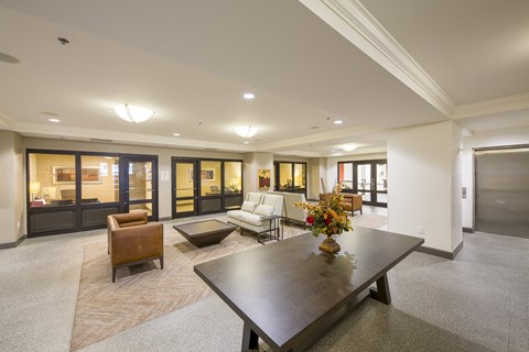 A modern living room with a dark wood coffee table and a white couch.