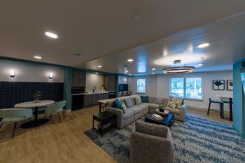 A living room with a couch, chairs, and a dining table.