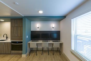 A kitchen with a table and chairs in front of a television.