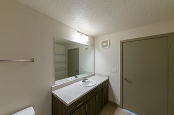 A bathroom with a sink, mirror, and toilet.