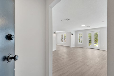 the living room and dining room of a new home with white walls and wood floors